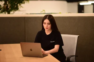 Salome Mikadze sits at a table with her laptop.