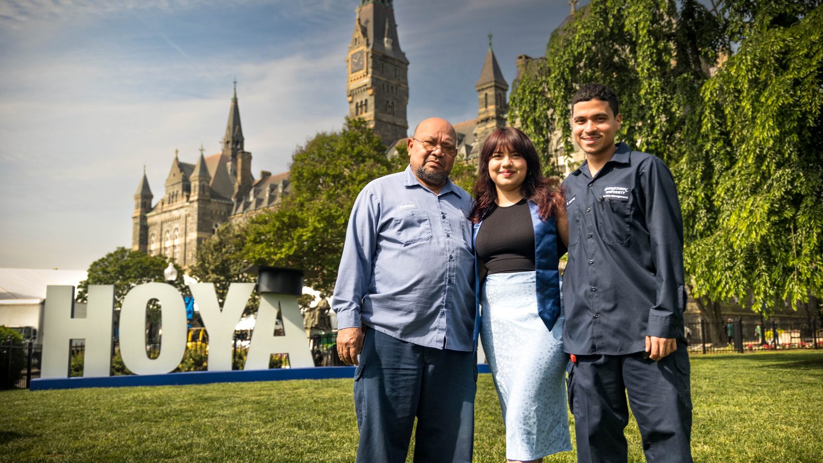The Velasquez family stands in front of the Hoya Saxa sign on Georgetown&#039;s front lawn.