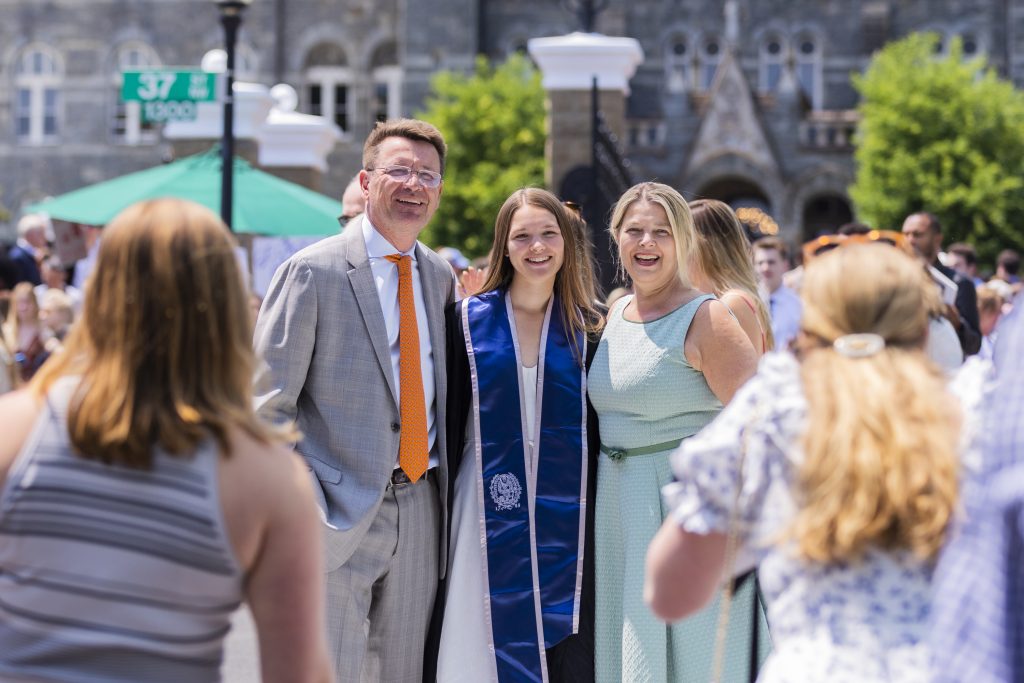 A graduate poses with her family for a photo in Healy Circle
