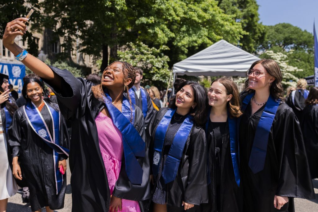 Four Georgetown graduates take a selfie after finishing Senior Convocation
