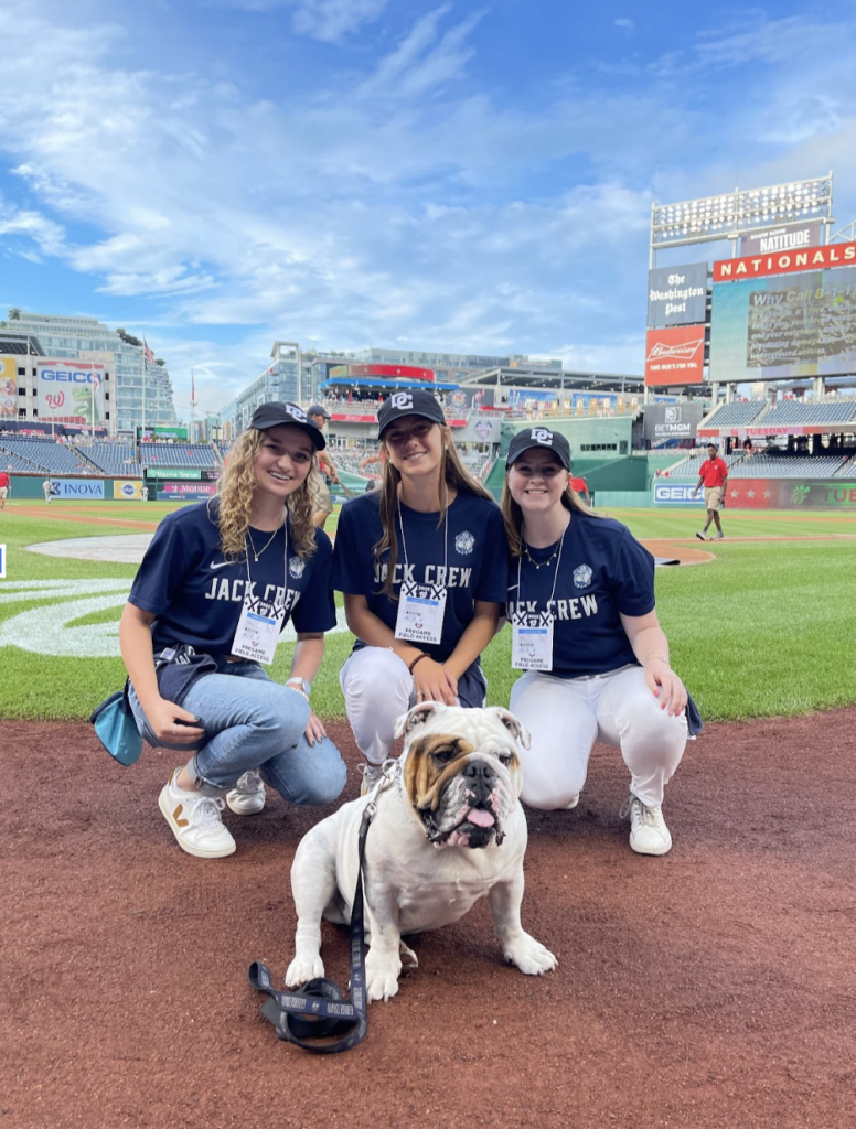 Three members of Jack Crew pose with Jack the Bulldog at the National's stadium.
