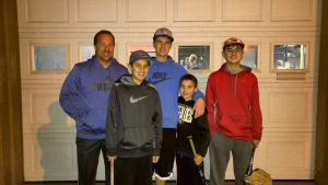 Justin Cassera with his three brothers and father in front of a garage door.