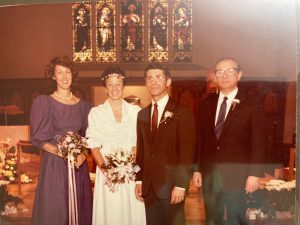 Dr. Anthony Fauci and his wife, Christine Grady, stand before the altar of Dahlgren Chapel in 1985 on their wedding day. They are flanked by their maid of honor (far left) and best man (far right).