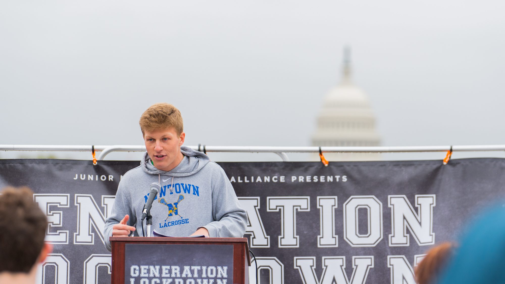Jackson Mittleman (C&#039;23) speaks at a rally for gun violence prevention. Behind him is a sign that says &quot;Generation Lockdown&quot; and the U.S. Capitol is in the foreground.