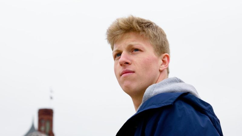 Jackson Mittleman (C&#039;23) looks thoughtfully on past the camera on a gray, rainy day.