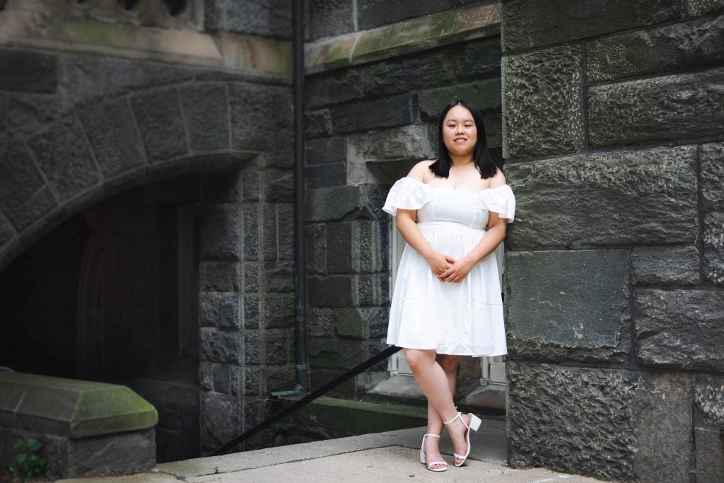 Chen Ma (B'23) leans against the stone wall of Healy Hall, near where the Georgetown Scholars Program office will be located.