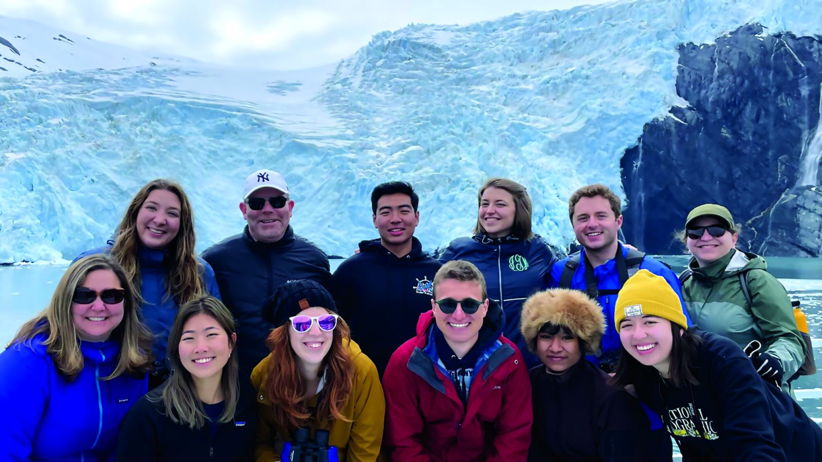 A group of Hoyas huddle together in front of a glacier in Alaska.