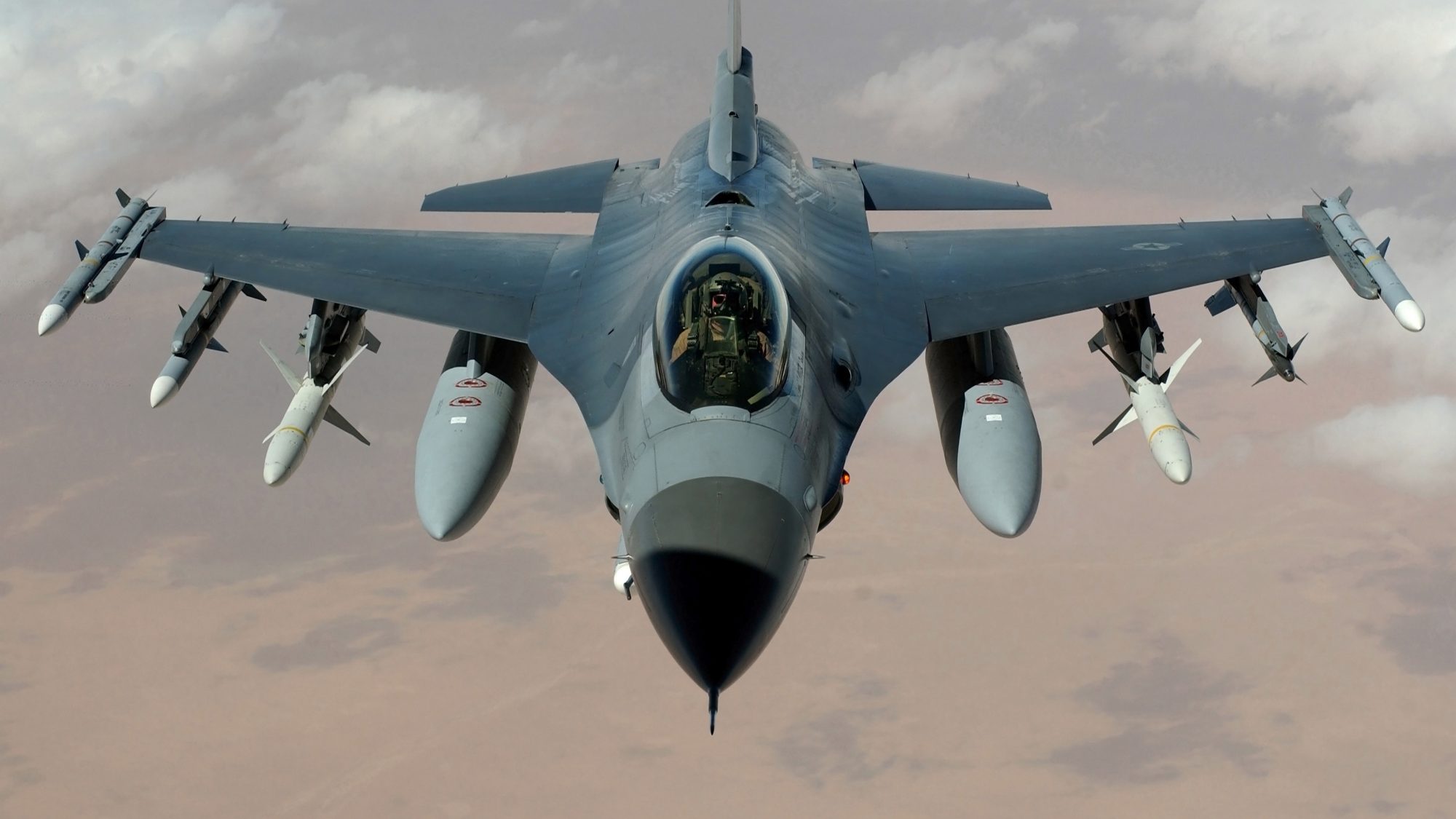 A fighter jet flying over a desert