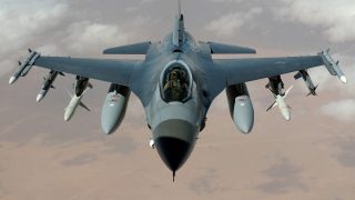 A fighter jet flying over a desert