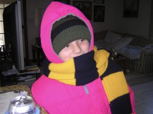 Childhood photo of Clark in a pink jacket with a striped scarf