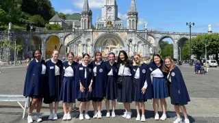Nursing students stand for a group photo in Lourdes on a sunny day