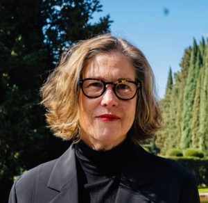 Headshot of Kathleen McNamara wearing glasses and a black blazer.