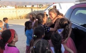 Yara surrounded by children on a sunny day