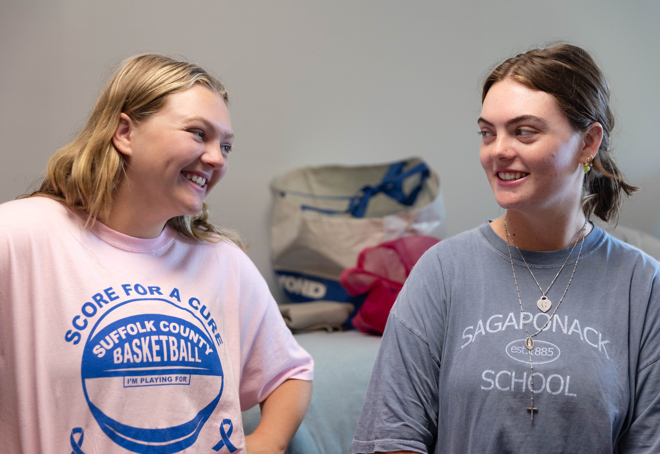 Two sisters smile at one another inside a dorm room at Georgetown.