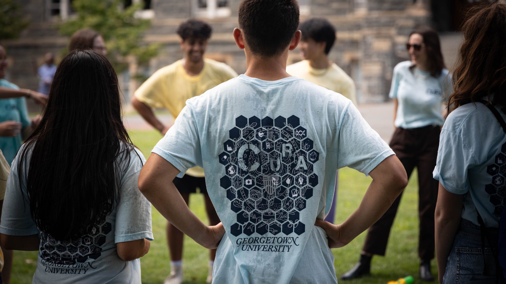 Students in a circle with one student wearing a blue shirt from CURA program