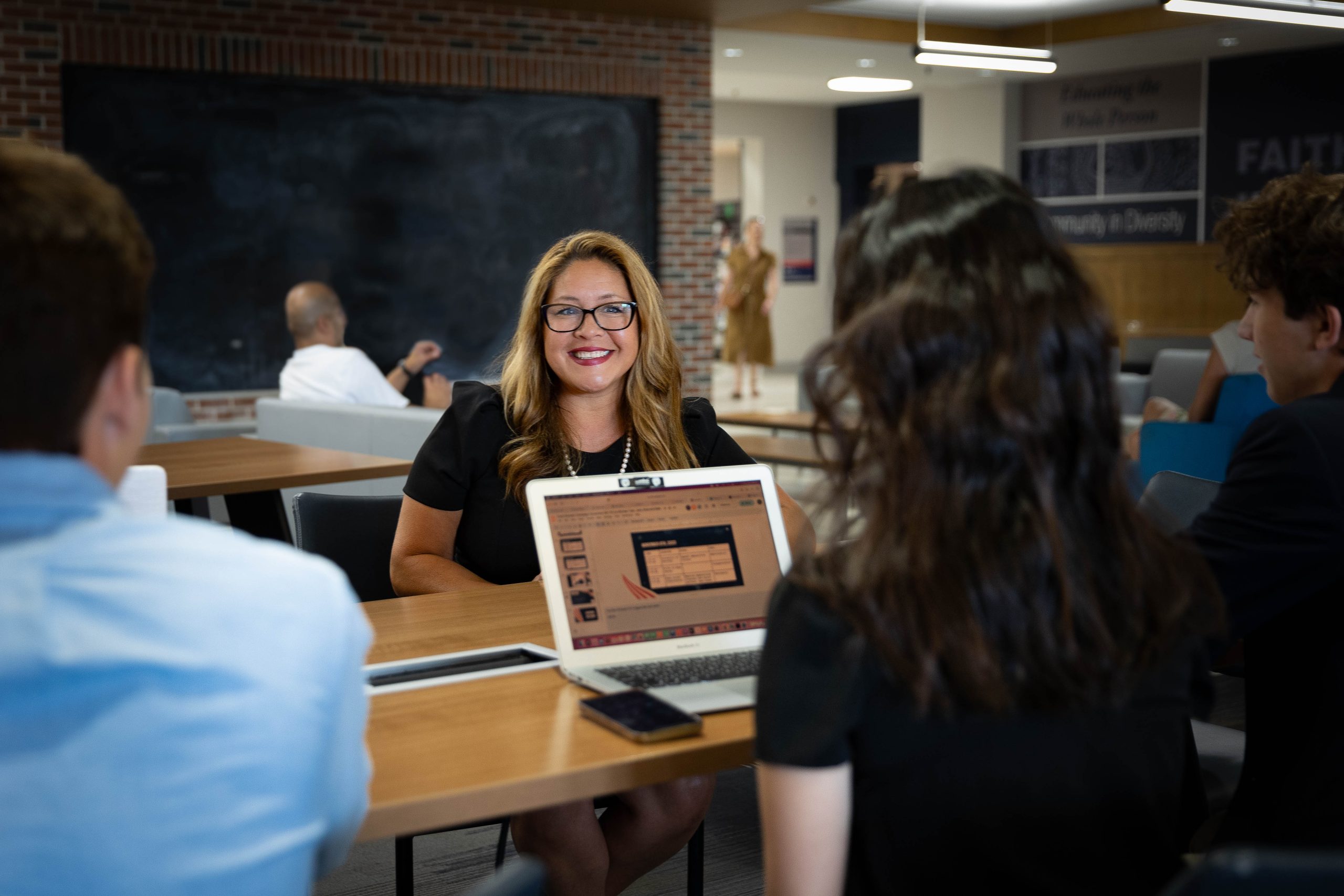 Georgetown's new dean of students smiles at a student who's looking at her laptop.