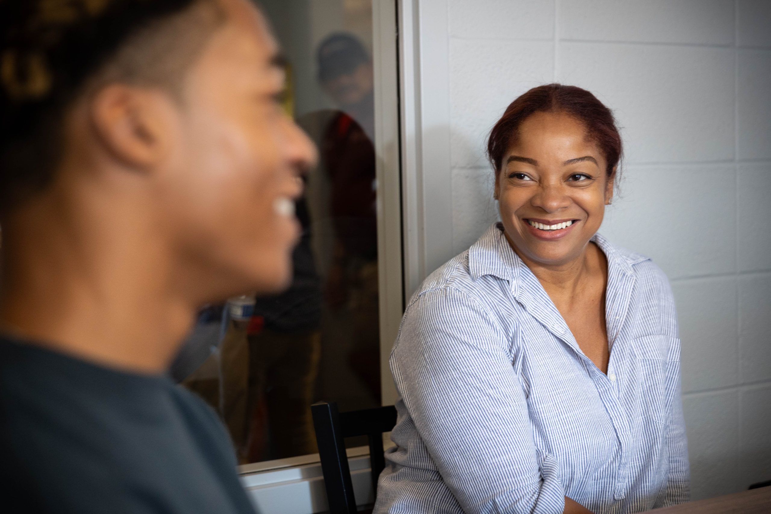 A mother smiles proudly at her son in a dorm at Georgetown.