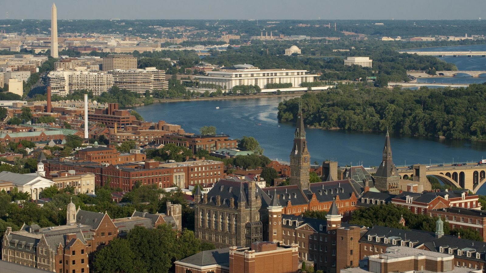 An aerial view of Georgetown&#039;s campus with the Washington monument and Potomac in the background.