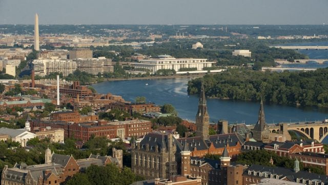 An aerial view of Georgetown&#039;s campus with the Washington monument and Potomac in the background.