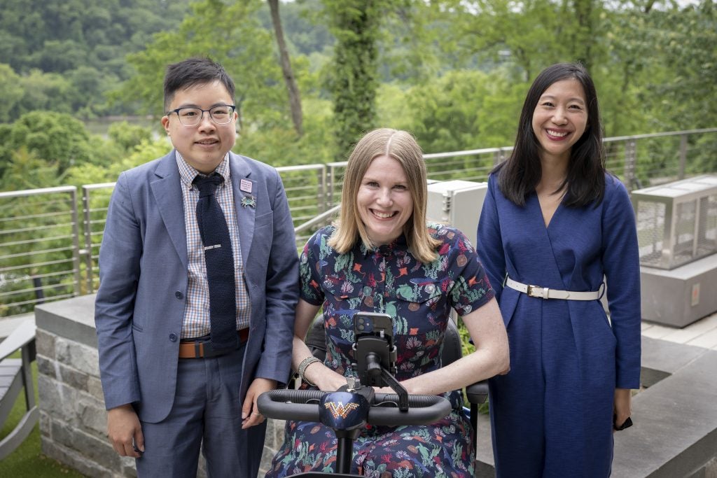 A group of staff and faculty members pose outside Georgetown at a graduation ceremony for students with disabilities. 