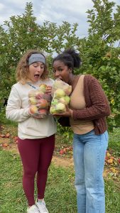 Two friends pose with apples they picked at a local orchard