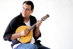 Tiago do Bandolim, with mandolin, looking into distance.