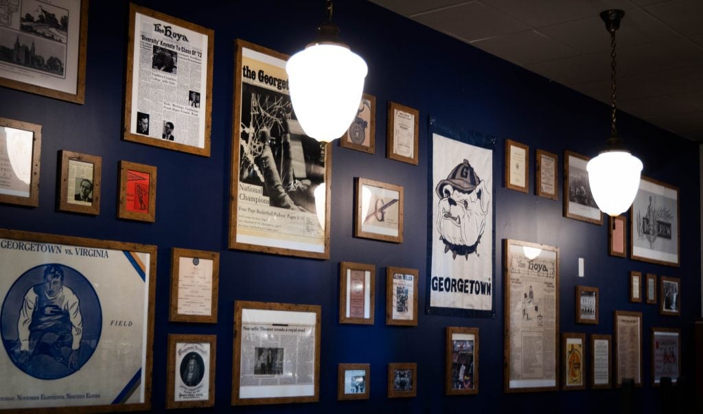 A collection of framed archive photos related to Georgetown hang on the wall of a new tap room on campus.