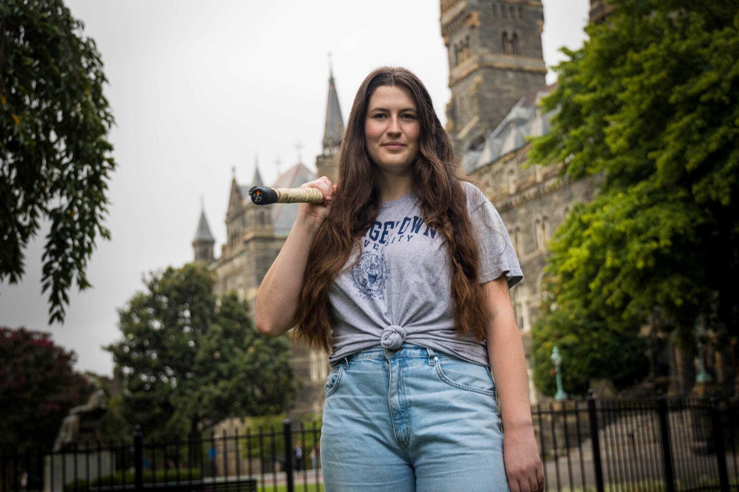 Sydney Carroll in front of Healy Hall with a baseball hat