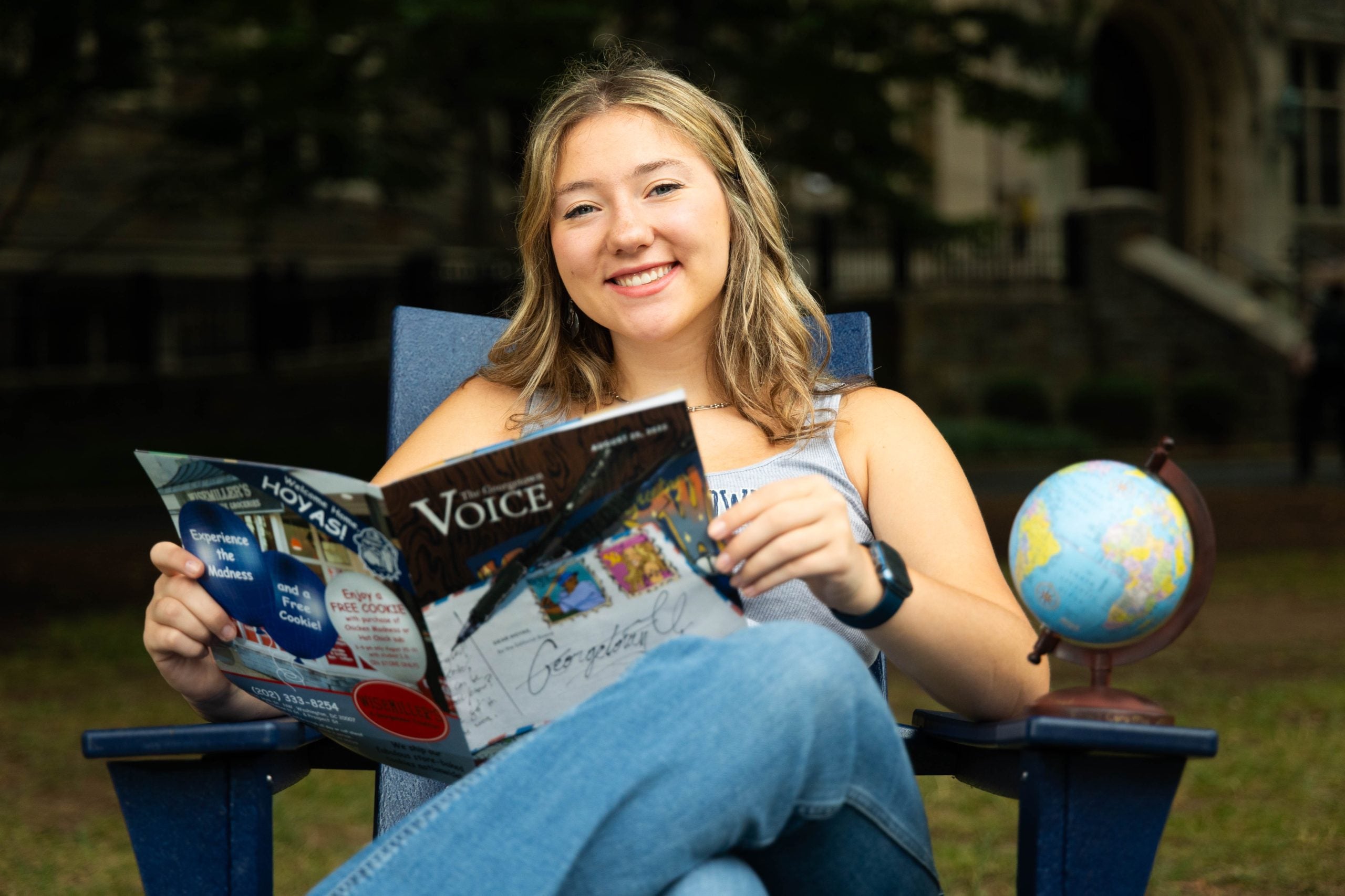 Ninabella Arlis sitting on a chair with a magazine