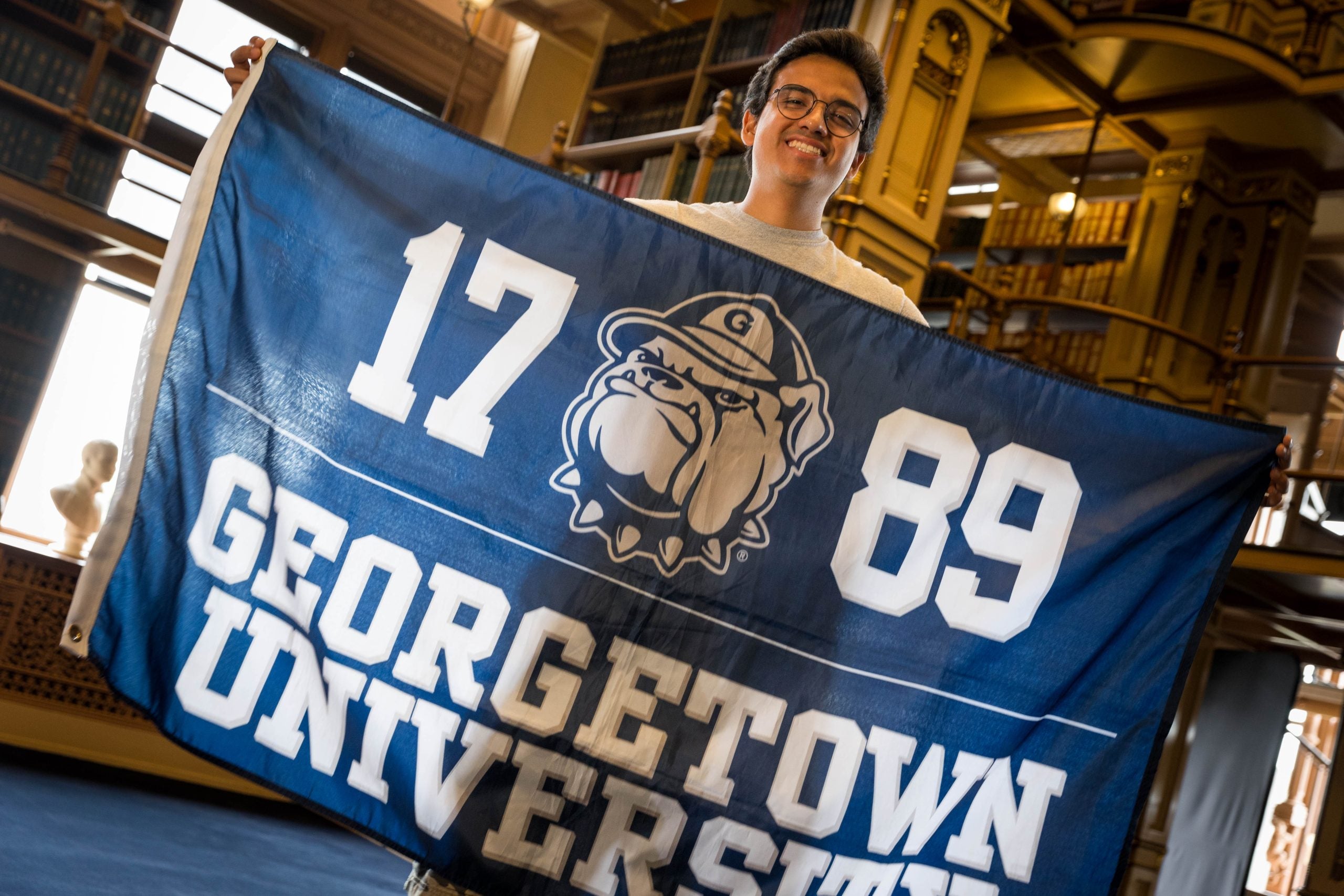 Renato Llontop Calosi in Riggs Library with a GU flag