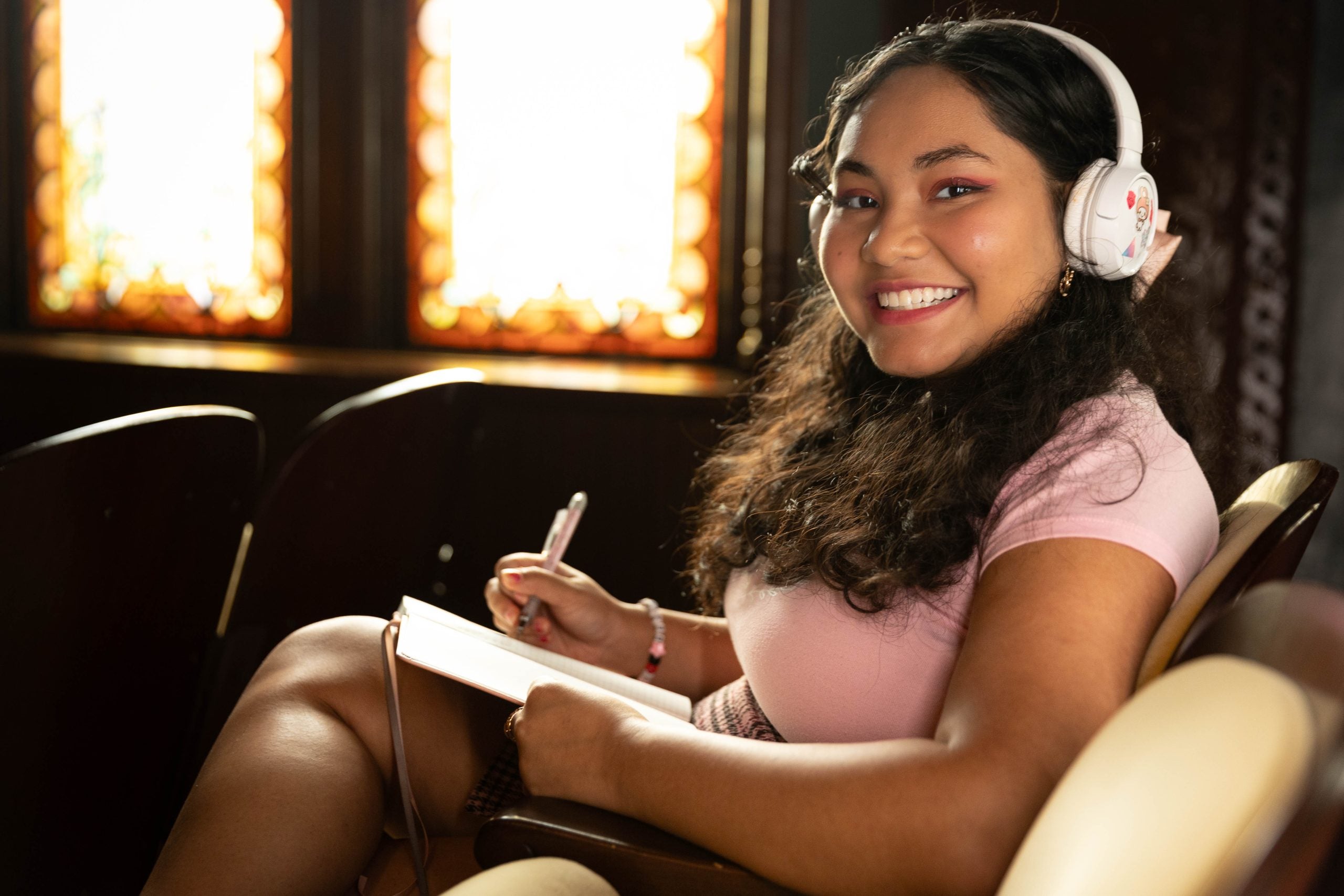 Mara Goldstein with headphones and a notebook