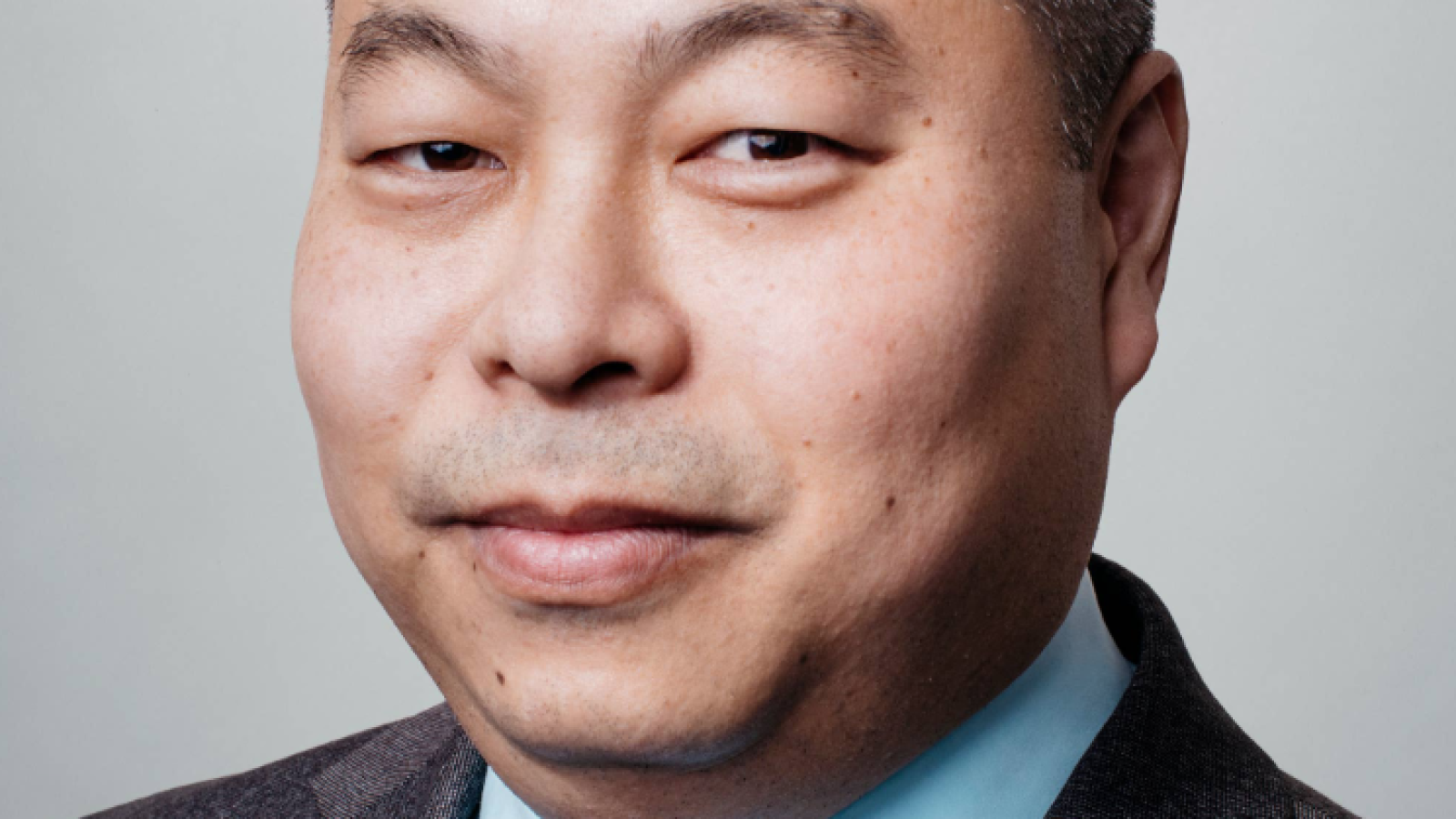 Ted Kim, wearing suit, looking at camera.