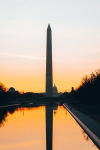Washington Monument and the reflecting pool backed by an orange sunrise