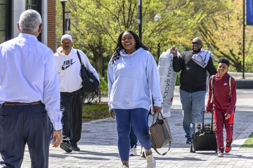 Tasha Butts, the late head coach of Georgetown's women's basketball team, walks down a pathway smiling at the university.