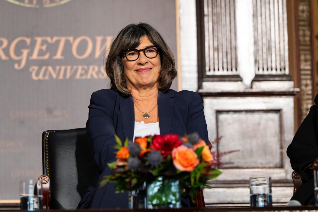 Christiane Amanpour smiles on the stage of Georgetown's Gaston Hall.