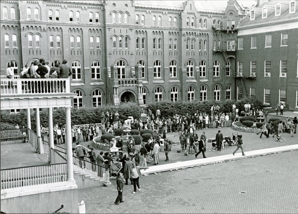 Black and white photo of film production behind Healy Hall