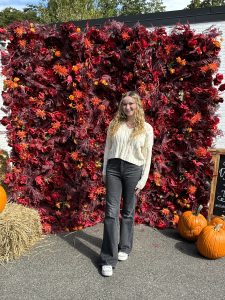 Girl poses in front of a fall background