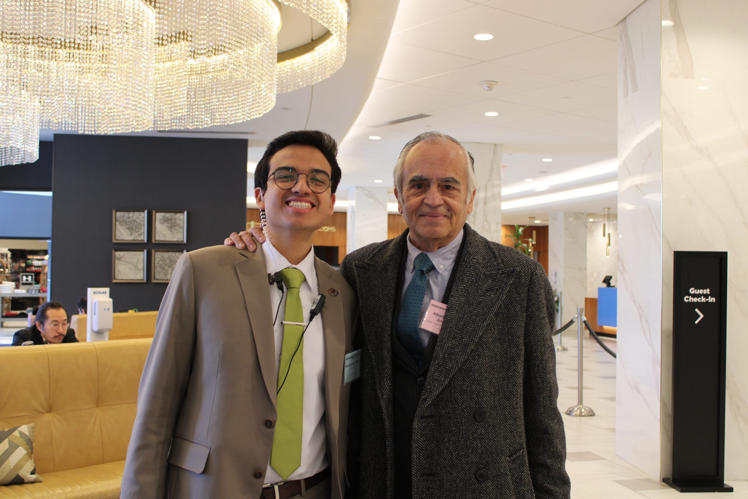 Students stands smiling with his former high school faculty advisor at a NAIMUN competition