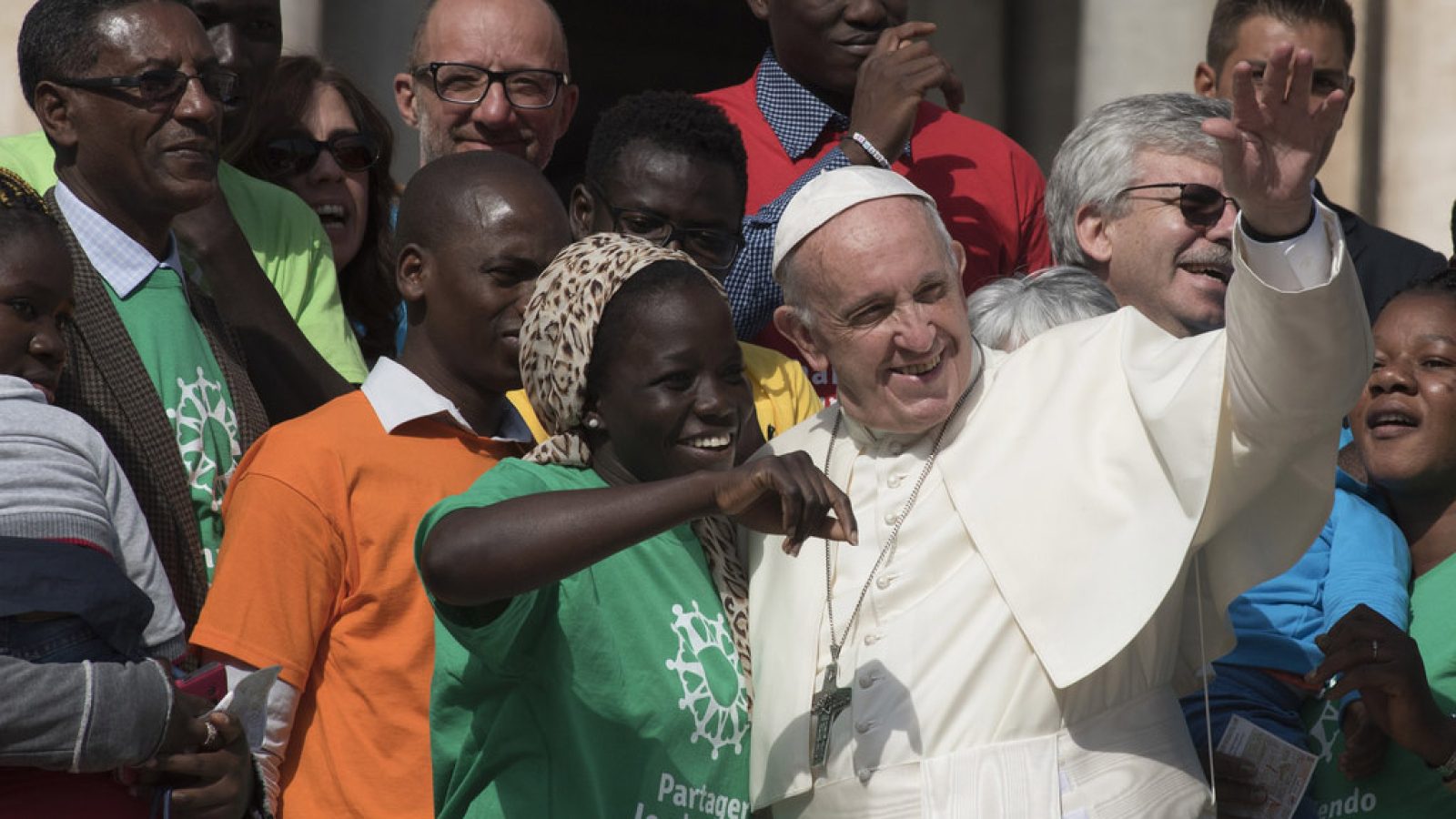 Pope Francis standing with migrants