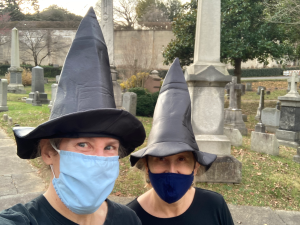 Two women in witches hats with masks on