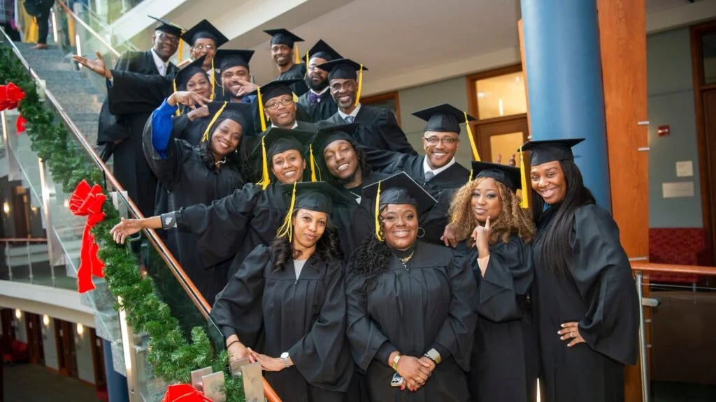 Group of graduates in robes posing on a staircase