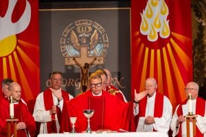 Catholic priest in red garments celebrates Mass