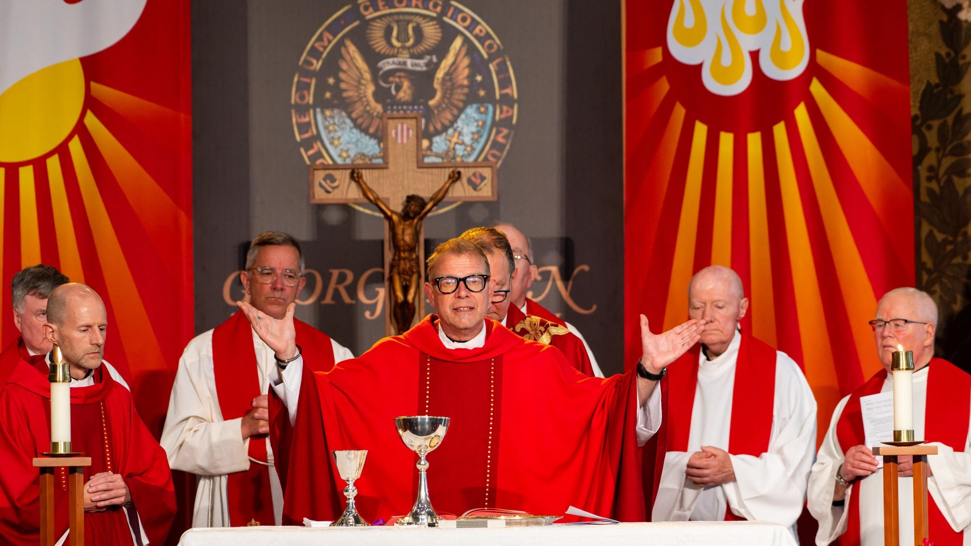 Catholic priest in red garments celebrates Mass