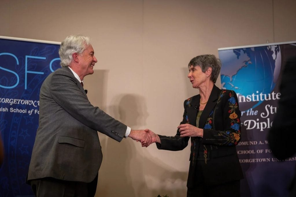 Man shakes woman's hand on stage