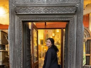 A student looks back at the camera from inside a doorway exhibit at a museum in Qatar.