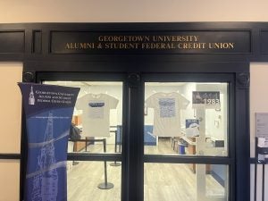 Entrance to GUASFCU Branch, two doors with GUASFCU t-shirts hanging in the windows