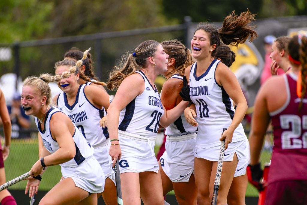 Female field hockey players celebrate