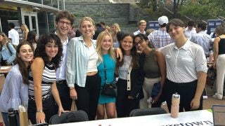 Students smile around a table adorned with a &quot;Georgetown Eco-consultants&quot; sign