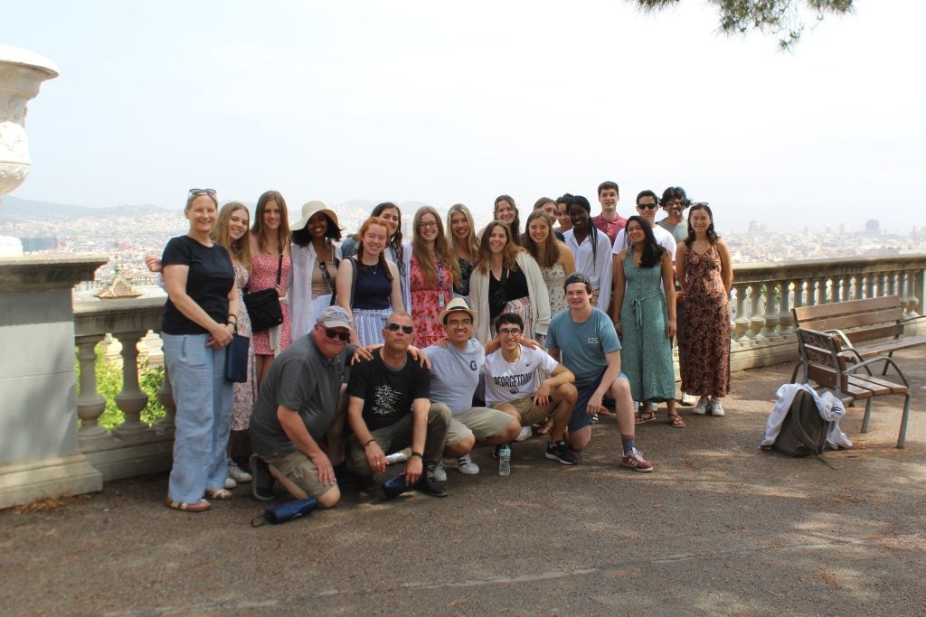 A group of young people standing by a railing in Spain outside