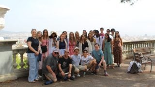 A group of young people standing by a railing in Spain outside